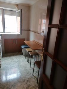 a room with a table and chairs and a window at Apartamento cerca del centro in Oviedo