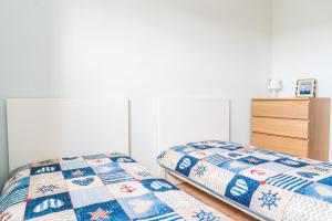 a bedroom with two twin beds and a dresser at Yacht Apartments in Wilkasy