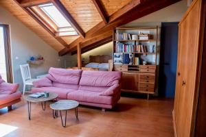 een woonkamer met een roze bank en een boekenplank bij Country style attic in the heart of Preveza in Preveza