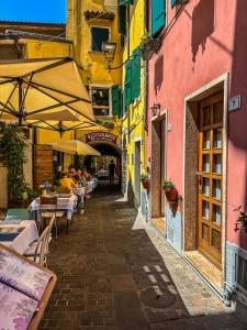 Un callejón con gente sentada en mesas en un callejón en Casa Cavour, en Garda