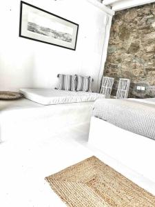 2 posti letto in una camera bianca con 2 sedie di Mykonos lovely apartment a Mykonos Città