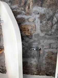a stone wall with a shower in a bathroom at Mykonos lovely apartment in Mikonos