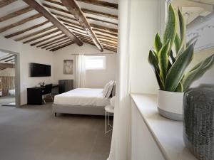 1 dormitorio con 1 cama y una maceta en New Moon Rooms, en La Spezia