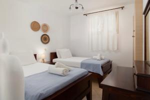 a room with two beds and a window at Almar Apartments in Batsi