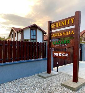 a sign in front of a fence in front of a house at Serenity Garden Villa in Runcu