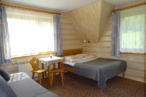 1 dormitorio con 2 camas, mesa y 2 sillas en U lisa en Zakopane