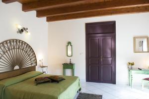 Schlafzimmer mit einem Bett und einer Holztür in der Unterkunft Case D'Anna in Castellammare del Golfo