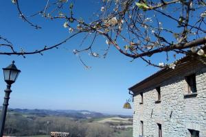 un edificio de piedra con un semáforo y un árbol en Ca' Növa, en Valverde Pavia