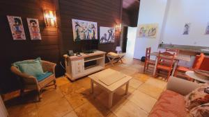 uma sala de estar com uma televisão, cadeiras e uma mesa em Siri Paraiso Hotel em Touros