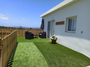 GuineaにあるVilla la cuadraの塀と芝生の小さな裏庭