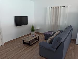 sala de estar con sofá, mesa y TV en Villa la cuadra, en Guinea