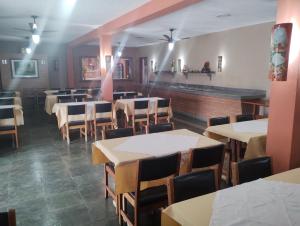 uma sala de jantar com mesas e cadeiras em Pousada Solar das Palmeiras em Joanópolis