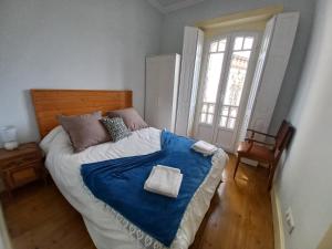 um quarto com uma cama grande e um cobertor azul em CASA MARIANA 2 - Viver a Vila em Sintra