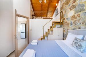 um quarto com uma cama e uma parede de pedra em Villa Lithos em Chrysi Ammoudia