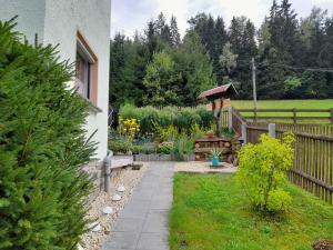 um jardim com uma cerca de madeira e um gazebo em Ferienhaus Rosemarie Erlbach Vogtland em Erlbach
