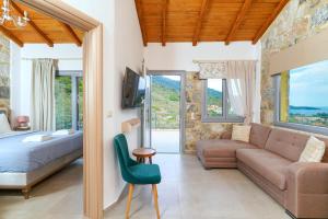 a bedroom with a bed and a couch and a table at Villa Lithos in Chrysi Ammoudia