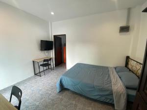 a bedroom with a bed and a desk and a television at Кондо в райском уголке Равай in Rawai Beach