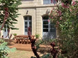 een houten terras met een tafel en stoelen op een huis bij L'Oasis de La Roquette in Arles