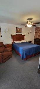 a bedroom with a bed and a couch and a ceiling fan at Husker Inn in North Platte