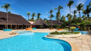 a swimming pool at a resort with palm trees at Siri Paraiso Hotel in Touros