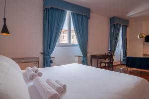Umbrian Concierge - Cozy Loft Vannucci في بيروجيا: غرفة نوم بسرير ابيض كبير عليها مناشف