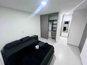 a bedroom with a black bed in a white room at 2403 Apto privado con vista en el centro de B/ga in Bucaramanga