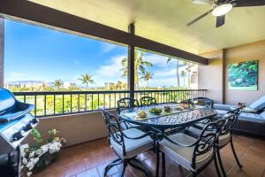 a dining room with a table and chairs and a balcony at KBM Resorts KRO-K302 2B Villa with free Rental car in Kaanapali