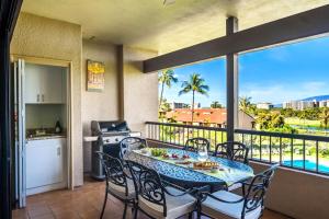 a balcony with a table and chairs and a kitchen at KBM Resorts KRO-K302 2B Villa with free Rental car in Kaanapali