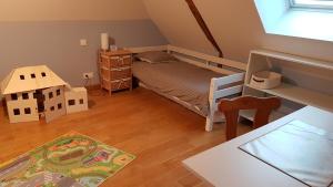mała sypialnia z łóżkiem i małym domkiem w obiekcie Maison Béthanie w mieście Russy