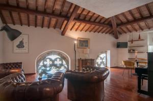 un soggiorno con mobili in pelle e un arco di Umbrian Concierge - Cozy Loft Vannucci a Perugia