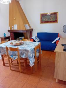 a living room with a table and a blue couch at Luna e Mare in Cala Gonone