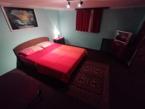 a bedroom with a red bed with a red blanket at Libero house in Smederevo