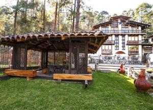 a pavilion in a yard with a house in the background at Hotel Boutique El Rincón in Zacatlán