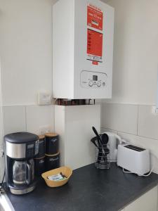 um balcão de cozinha com comodidades para preparar café e uma torradeira em Newly Built Studio Flat Sleeps 2 em Kent