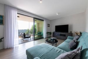een woonkamer met een blauwe bank en een televisie bij Apartment Mint in Dubrovnik