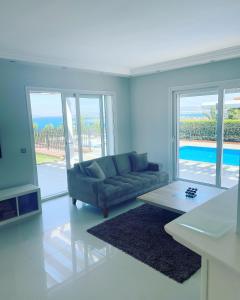 ein Wohnzimmer mit einem Sofa und einem Tisch in der Unterkunft Luxury Villa with amazing view, Cesme in Cesme