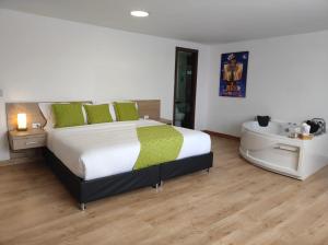 a bedroom with a large bed and a bath tub at Nogal Suite Hotel Ipiales in Ipiales +45 photos