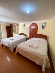 HOUSE MIRAFLORES في كاخاماركا: سريرين في غرفة الفندق عليها مناشف