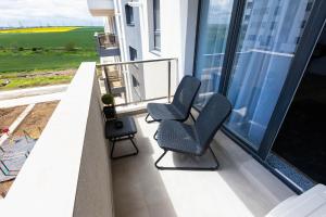 2 chaises assises sur le balcon d'un bâtiment dans l'établissement Maurer Apartment, à Constanţa