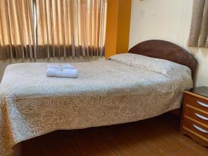 - une chambre avec un lit et une serviette bleue dans l'établissement HOUSE MIRAFLORES, à Cajamarca