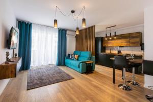- un salon avec un canapé bleu et une table dans l'établissement Maurer Apartment, à Constanţa