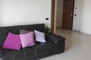Casa Mara في Macchie: أريكة جلدية سوداء عليها ثلاث وسائد