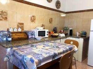 una cucina con tavolo e forno a microonde su un bancone di A casa di Maria a Ozieri