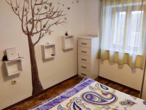 a bedroom with a tree painted on the wall at Apartment Romy for 2-4 people with jacuzzi in Motovun