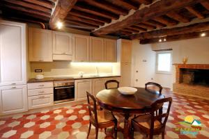 una cucina con tavolo e sedie in una stanza di Maremma Holidays- La Casa Di Rocca a Scarlino