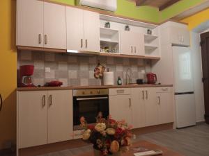 a kitchen with white cabinets and a table at GS APARTMENT in Gythio +20 photos