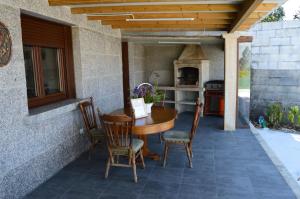 a table and chairs on a patio with a kitchen at Preciosa casa con aparcamiento a 1km de la Toja in O Grove