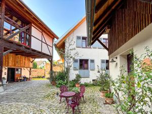 a patio with tables and chairs and a building at Storchenhof Teningen in Teningen