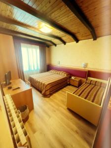 een grote kamer met 2 bedden en een bureau bij Hotel Montegrande in Vidiciatico