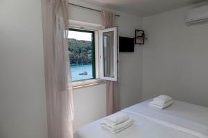 una camera con letto e finestra con asciugamani di Lučica, Luxury Rooms By the Sea a Pučišća